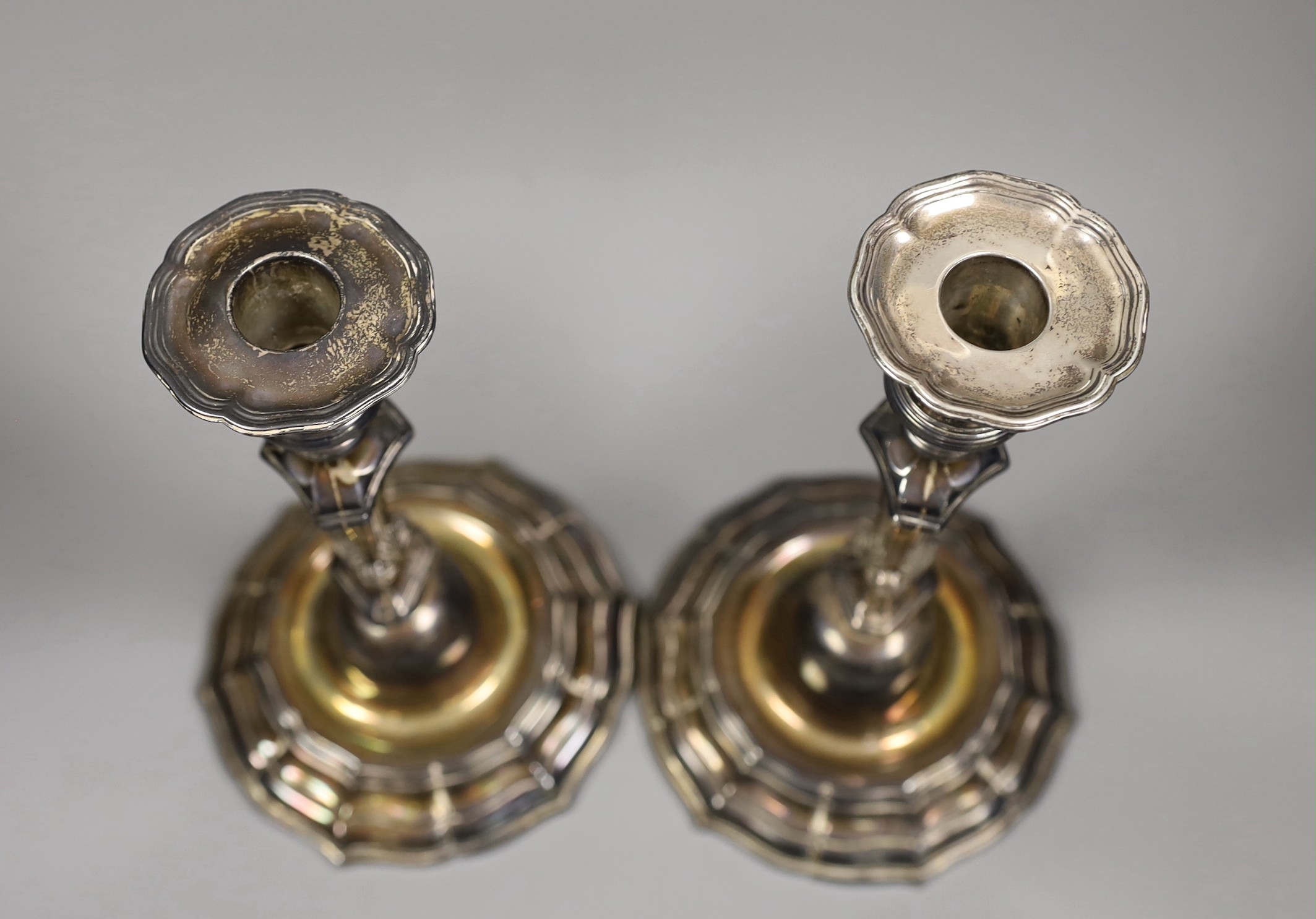 A pair of French Louis XVI cast white metal candlesticks and sconces, with waisted knopped stems, on shaped circular bases, maker, Jean Schoutheer, Dunkirk mark, circa 1775, height 26.2cm, 36oz.